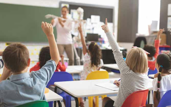 Children raising their hands in a classroom
