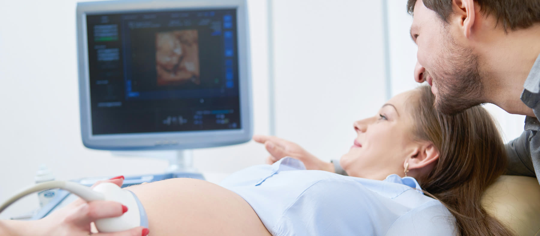 An expectant couple watching an ultrasound